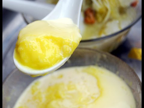 Khi đậu chín và còn nóng, cho vào máy xay cùng cơm sầu riêng, một phần nước dừa tươi, đường thốt nốt, xay nhuyễn. Hòa bột năng vào phần nước dừa còn lại. Cho hỗn hợp sầu riêng, đậu đã xay vào chảo cùng phần nước dừa pha bột năng. Ảnh: youtube