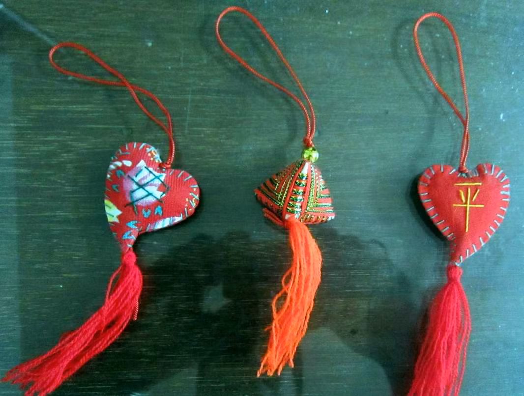 Nhiều nhà có tục mua bùa chỉ ngũ sắc đeo cho trẻ con, may áo lụa mang đến cửa chùa, in dấu vẽ bùa rồi mặc cho trẻ con với ý trừ ma trừ tà. Ảnh: Internet.