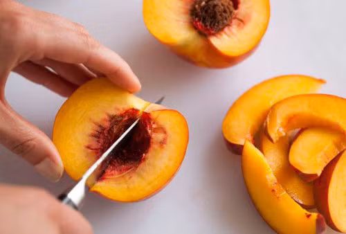 Đào chọn quả chín mềm vì đào chín giúp tạo màu sắc và vị ngọt đúng hương vị của sinh tố đào. Sau đó rửa sạch đào, để ráo rồi bổ đào thành múi cau và bỏ hạt. Nếu đào nhiều lông thì nên gọt vỏ trước. Ảnh: vietgiaitri