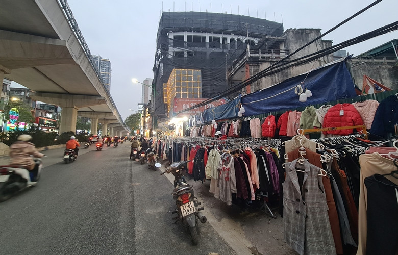 Quần áo giảm giá còn được bày bán la liệt dọc vỉa hè đường Cầu Giấy.