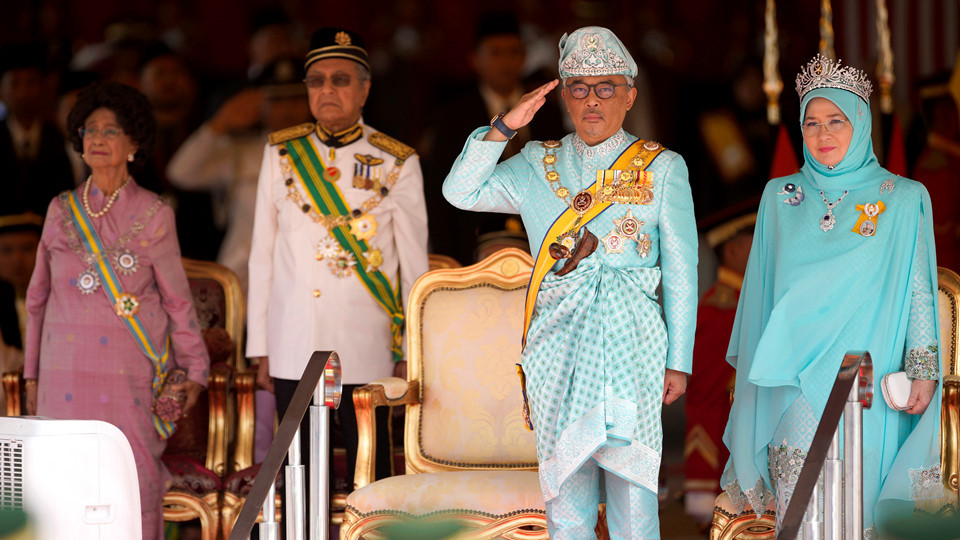 Quốc vương Abdullah đứng bên cạnh Hoàng hậu Tunku Azizah Aminah Maimunah trong buổi lễ chào mừng nhà vua tại Tòa nhà Quốc hội ở Kuala Lumpur. Thủ tướng Malaysia Mahathir Mohamad và phu nhân đứng ở phía sau. Thủ tướng Mahathir, các bộ trưởng chính phủ và các thành viên của quốc hội đã chào đón vị vua mới tại tòa nhà quốc hội trước khi ông đăng quang. Ảnh: AP.