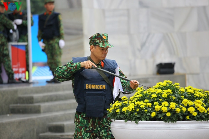 Lực lượng Công binh (Bộ Quốc phòng) rà soát từng khóm hoa, bụi cỏ tại khu vực Trung tâm báo chí để đảm bảo an ninh.