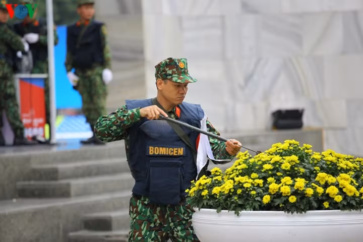 Lực lượng Công binh (Bộ Quốc phòng) rà soát từng khóm hoa, bụi cỏ tại khu vực Trung tâm báo chí để đảm bảo an ninh.