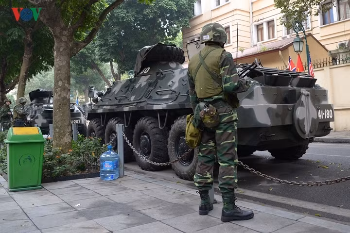 Các chiến sĩ quân đội đứng gác bên xe bọc thép.