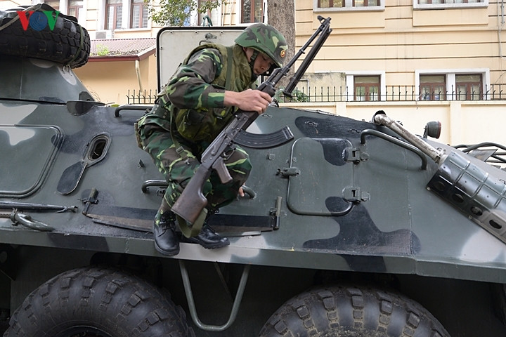 Một quân nhân nhảy từ xe thiết giáp xuống, trên tay là khẩu trung liên RPK.