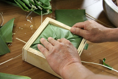 Bắt đầu gói bánh.