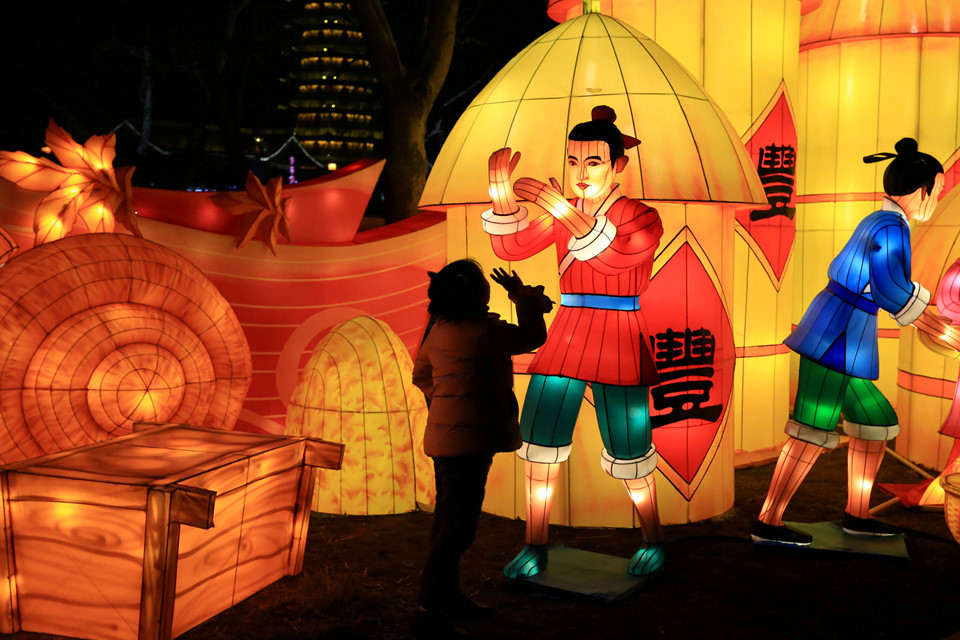 Một em nhỏ đang ngắm nhìn những đồ vật trang trí mừng Tết Nguyên đán ở tỉnh Giang Tô. Ảnh: Reuters.