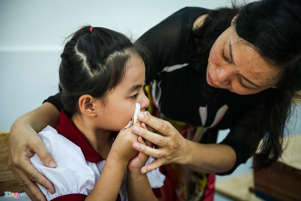 Nhiều bé vừa bật khóc, vừa gọi bố mẹ, các cô giáo phải đến dỗ dành. Con khóc nhiều trong ngày đầu đến trường, chị Huế (quận Bình Thạnh) dự định nghỉ làm hôm nay, ngồi ở sân trường chờ đến 10h để đón bé. “Lần đầu con đi học, ba mẹ cùng đưa cháu đến lớp. Tối hôm qua, bé còn rất háo hức, sáng dậy sớm thay đồng phục đến trường nhưng khi vào lớp lại khóc, chắc do lạ. Mình ngồi đây chờ tới giờ đón bé luôn, phòng khi có chuyện gì”, người mẹ tâm sự.