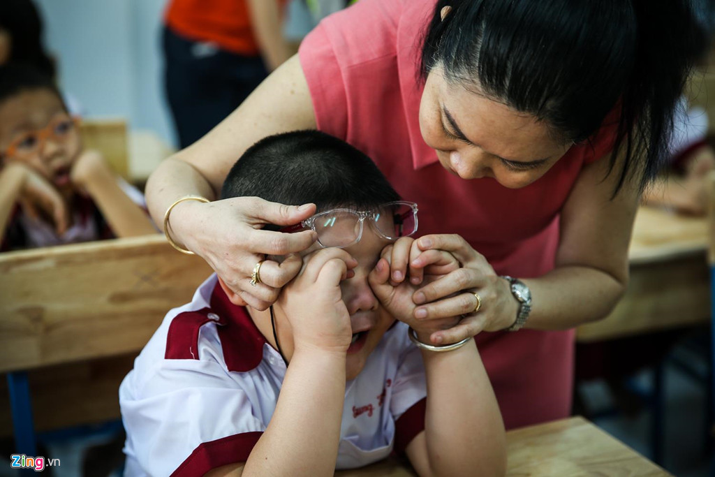 Bỡ ngỡ với trường lớp, thầy cô và bạn mới, nhiều bé vừa dứt vòng tay cha mẹ đã bật khóc. Nhiều bậc phụ huynh phải mất nhiều thời gian dỗ con. Không yên tâm, phụ huynh còn nán lại ngồi trong lớp cùng con.