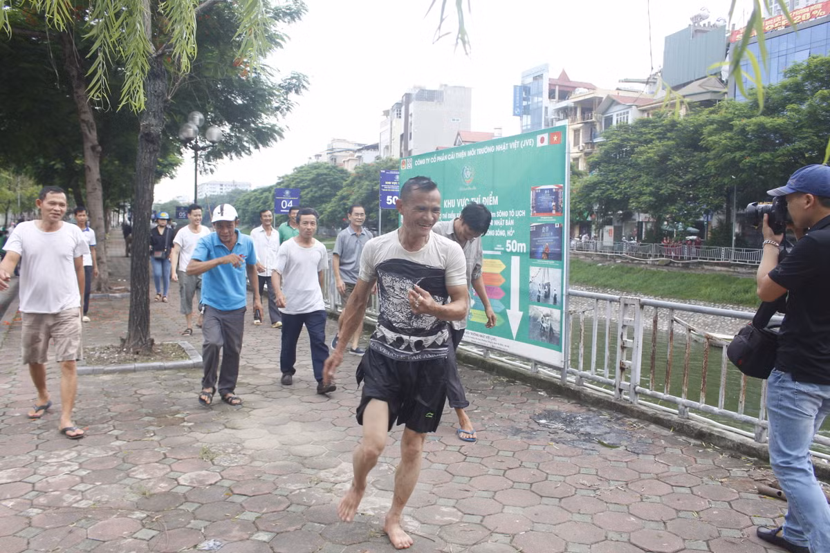 Một người câu được cá trê khủng, lao xuống dòng nước để vớt được cá lên vì cá quá to.