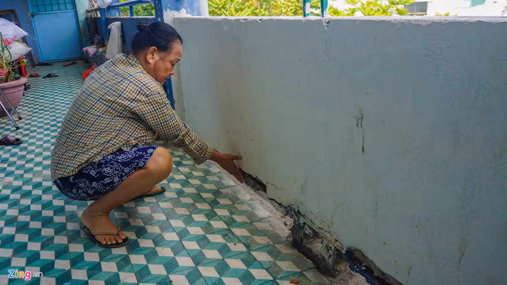 Chỉ tay về phía chân tường đã nứt toác, bà Thu Hường (cư dân sống ở chung cư Hòa Minh) bức xúc cho biết đã nhiều năm qua người dân phản ánh tình trạng chung cư hư hỏng với lãnh đạo địa phương nhưng chính quyền cũng chỉ sửa sơ sài.