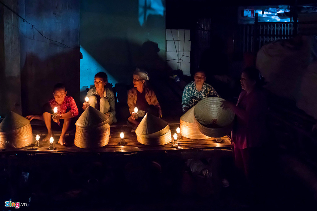 Phiên chợ đặc biệt nằm khuất trong một con hẻm ở Phù Cát, Bình Định, diễn ra vào lúc nửa đêm nên tiểu thương phải dùng đèn dầu hoặc đèn pin lấy ánh sáng để mua bán. Ảnh: Võ Việt.