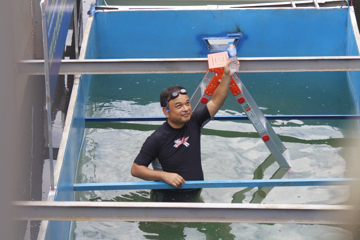 Đồng thời ông mang mẫu nước lên để cho các phóng viên và người dân có thể thấy rõ được thành quả của việc trình diễn.