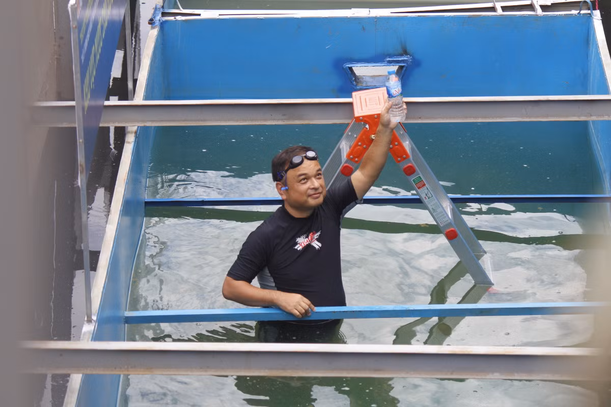 Đồng thời ông mang mẫu nước lên để cho các phóng viên và người dân có thể thấy rõ được thành quả của việc trình diễn.