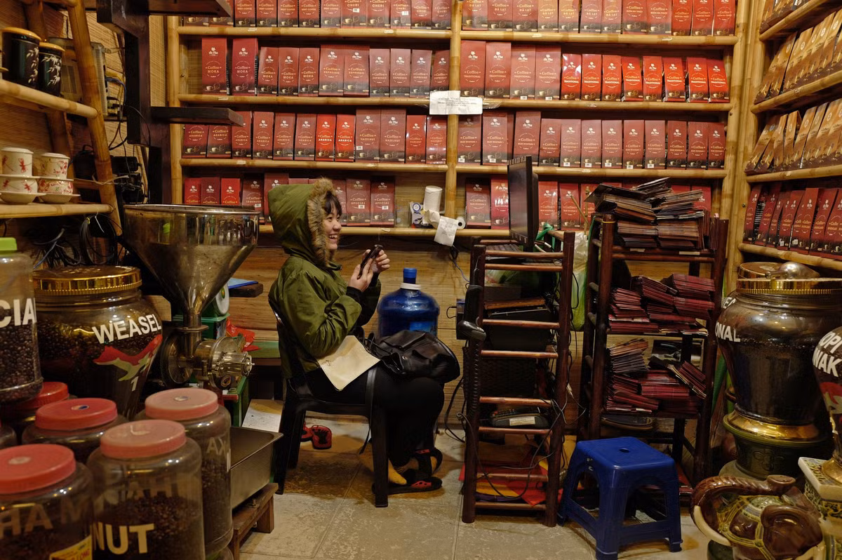 Cô gái ngồi bên trong một cửa hàng bán cà phê xay và cà phê hạt ở Hà Nội.