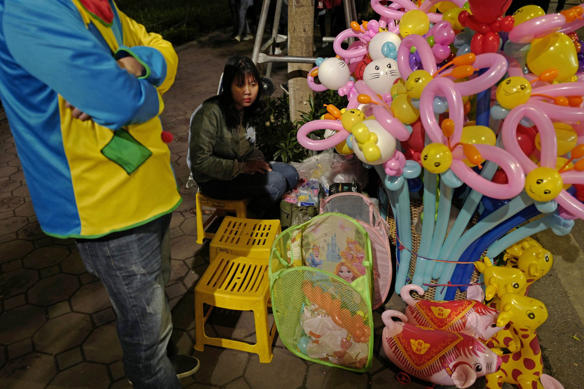 Những phóng viên quốc tế có thẻ tác nghiệp tại sự kiện trên có thể đăng ký danh sách tại Trung tâm báo chí quốc tế (IMC). Các hành trình này hoàn toàn miễn phí, do Công ty Lữ hành Saigontourist tổ chức. Trước mắt, các tour khám phá dành cho nhà báo quốc tế sẽ được triển khai trong hai ngày 27 và 28/2 và cân nhắc kéo dài hơn. Trong ảnh: Một người bán bóng bay gần bờ hồ Hoàn Kiếm.