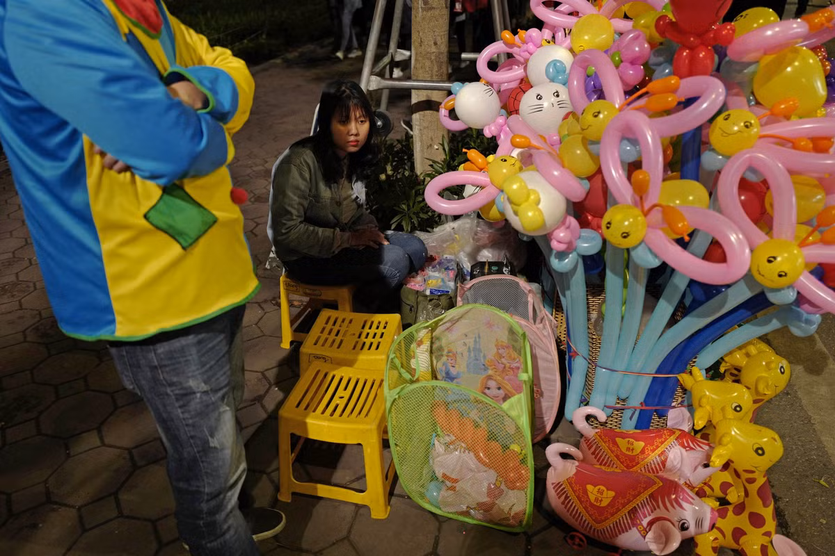 Những phóng viên quốc tế có thẻ tác nghiệp tại sự kiện trên có thể đăng ký danh sách tại Trung tâm báo chí quốc tế (IMC). Các hành trình này hoàn toàn miễn phí, do Công ty Lữ hành Saigontourist tổ chức. Trước mắt, các tour khám phá dành cho nhà báo quốc tế sẽ được triển khai trong hai ngày 27 và 28/2 và cân nhắc kéo dài hơn. Trong ảnh: Một người bán bóng bay gần bờ hồ Hoàn Kiếm.