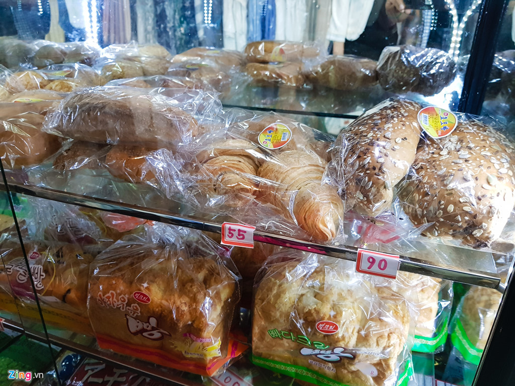 Các cửa hàng phổ biến ở Triều Tiên có diện tích khoảng 20 m2 với những tủ kính được đặt cạnh nhau với các sản phẩm khác nhau từ thịt cá, bánh mì đến bóp ví và cả nữ trang. Trong ảnh là tủ bày bán các loại bánh mì có giá dao động từ 55 won (đơn vị tiền tệ của Triều Tiên) khoảng 1.400 đồng. Tỷ giá quy đổi 1.000 won là khoảng 25.400 đồng.