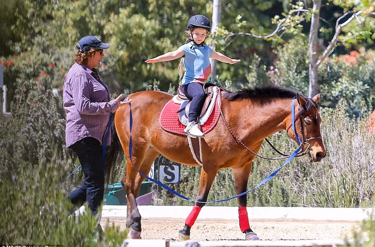 Ngày 11/4, Beck-Vic đưa con gái út Harper đi học cưỡi ngựa ở Los Angeles. Cô công chúa nhỏ nhà Beck-Vic vui vẻ tận hưởng bài học cưỡi ngựa đầu đời trong khi bố mẹ tự hào đứng xem con gái học. (Ảnh: Coleman-Rayner)