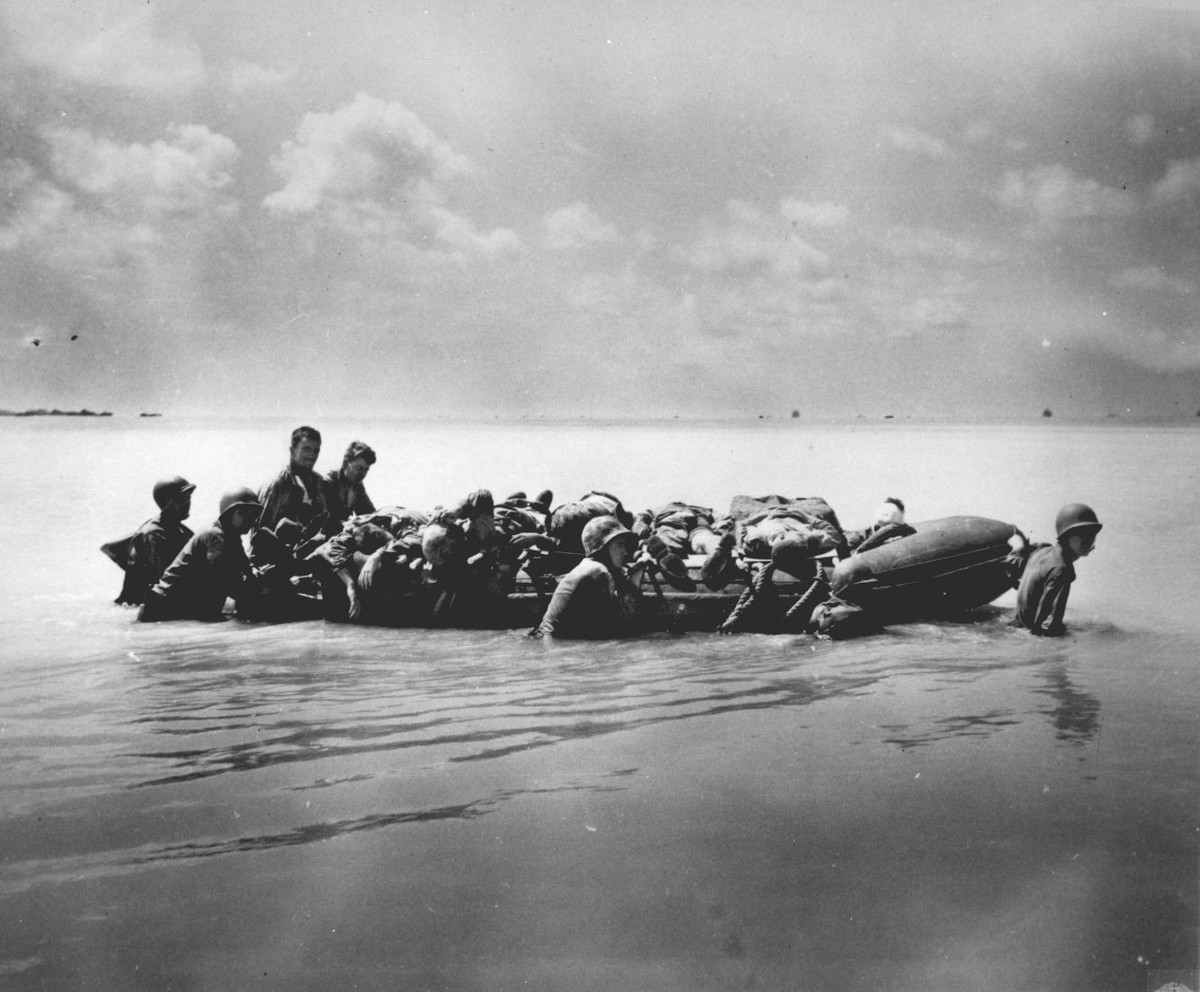 Thương binh được di chuyển bằng xuồng cao su ra chỗ nước sâu để đưa lên tàu vận tải. Nguồn ảnh: BI.