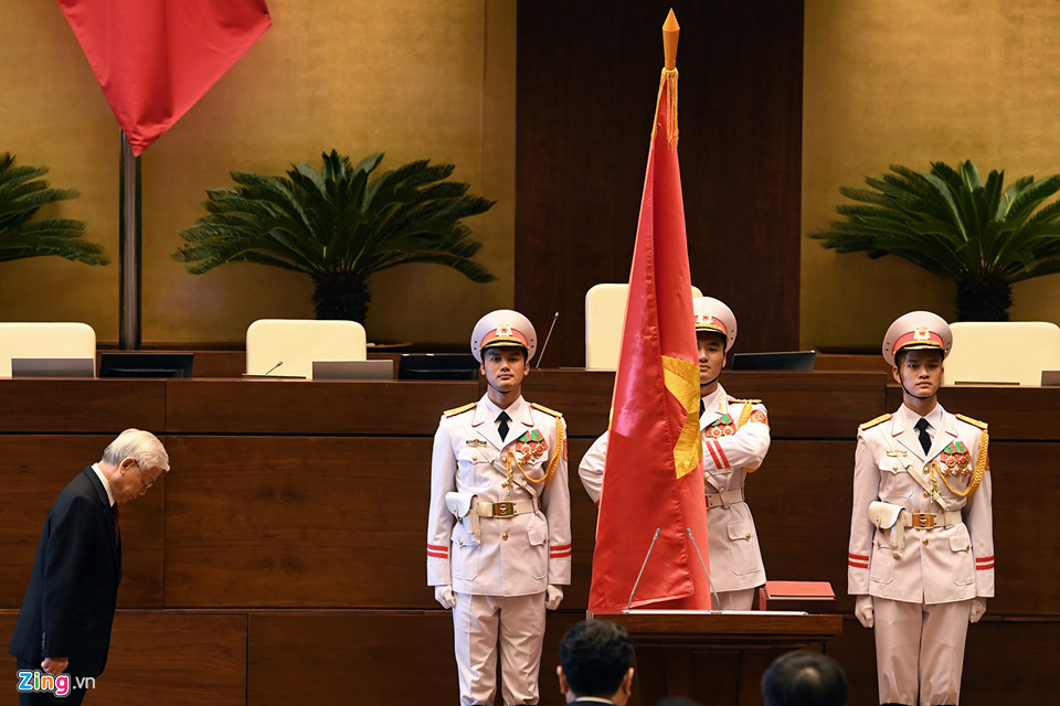 Tổng bí thư Nguyễn Phú Trọng cúi mình trước cờ Tổ quốc, trước khi đọc lời tuyên thệ.