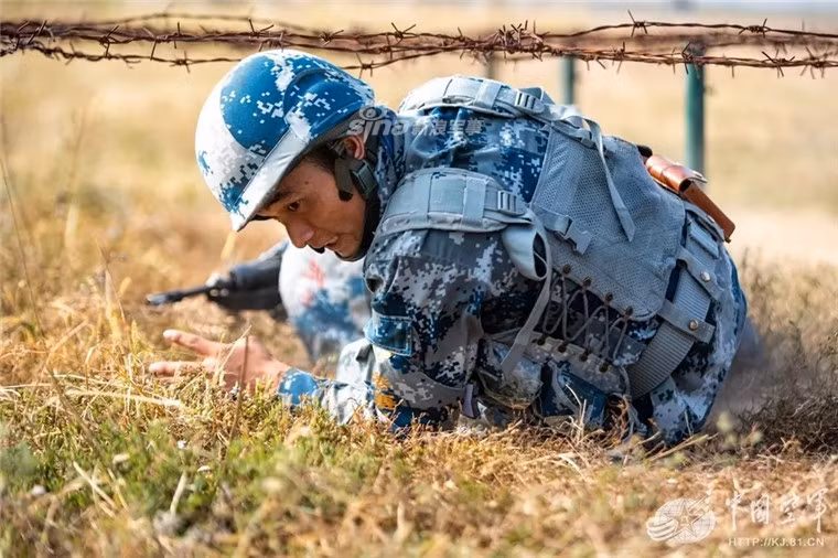 Tư thế trườn qua dây thép gai khá khác lạ của binh lính Trung Quốc. Nguồn ảnh: Sina.