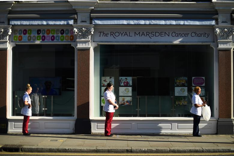 Các y tá đứng cách xa nhau khi xếp hàng nhận đồ ăn trưa tại thủ đô London ngày 25/3.