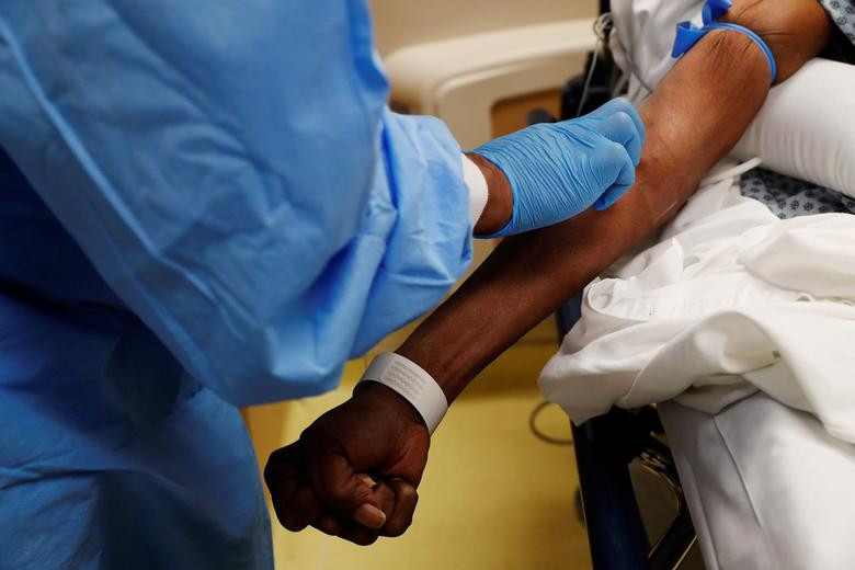 Y tá lấy máu từ bệnh nhân COVID-19 đang điều trị trong phòng cấp cứu tại bệnh viện ở thành phố Chicago.