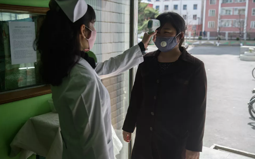 Dù chưa có trường hợp mắc bệnh, Triều Tiên vẫn triển khai nhiều biện pháp phòng dịch nghiêm ngặt, bao gồm đóng cửa biên giới và cách ly những người nghi nhiễm bệnh. Ảnh: Nhân viên y tế đo thân nhiệt của một phụ nữ ở lối vào Bệnh viện Nhân dân Phyongchon ở Bình Nhưỡng ngày 1/4.
