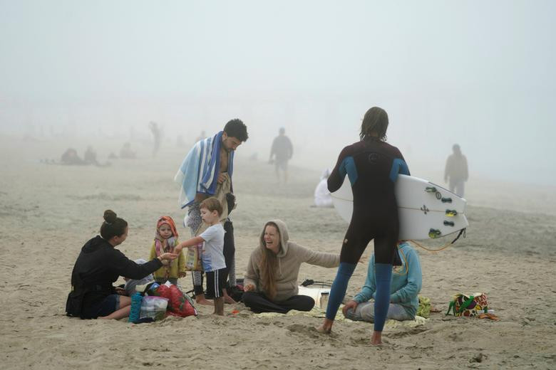 Nhiều người không đeo khẩu trang tại bãi biển thành phố Huntington, bang California, ngày 25/4.