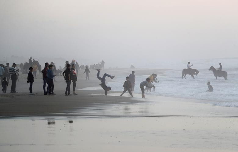 Người dân Palestine vui đùa trên bãi biển ở thành phố Gaza hôm 17/4, bấp chấp lo ngại về sự lây lan của dịch bệnh COVID-19.
