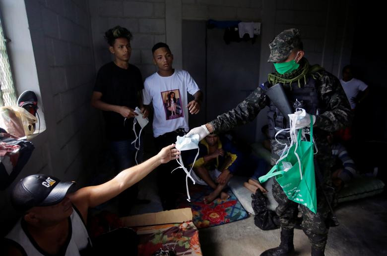Thành viên của Quân đội Honduras phát khẩu trang và nước rửa tay cho phạm nhân tại nhà tù Tamara, ngoại ô Tegucigalpa, hôm 27/3.