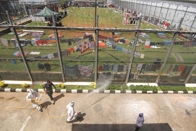 Nhân viên Hội Chữ Thập đỏ Indonesia phun thuốc khử trùng tại khu vực trại giam ở Depok, gần Jakarta, ngày 2/4. Mời độc giả xem thêm video: WHO chính thức đặt tên cho virus corona mới là SARS-CoV-2 (Nguồn video: VTC1)