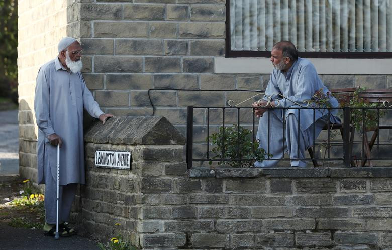 Hai người đàn ông giữ khoảng cách xã hội khi nói chuyện với nhau ở Halifax, Pháp, ngày 16/4.