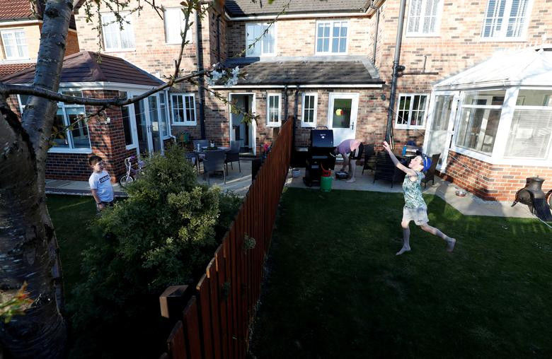 Bé Ethan (8 tuổi) và Fin (9 tuổi) chơi ném bóng qua hàng rào trong khu vườn ở Chester-le-Street, Anh, hôm 11/4.