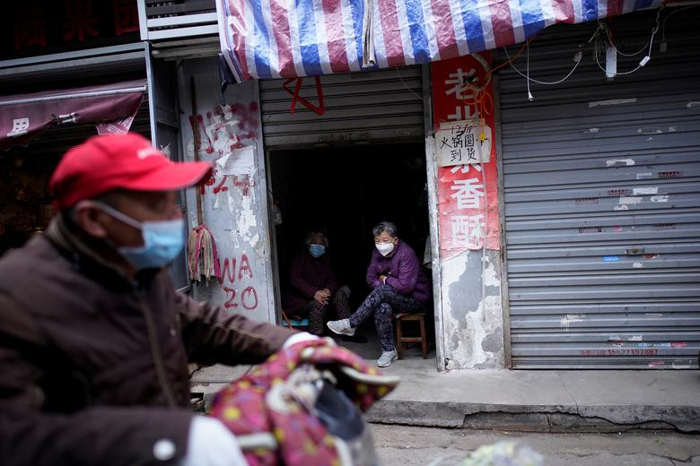 Người dân địa phương đeo khẩu trang khi ngồi trong nhà ở Vũ Hán hôm 11/4.