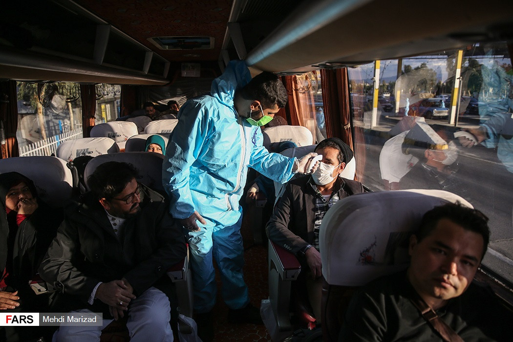 Nhân viên y tế Iran đo thân nhiệt của hành khách trên xe buýt.