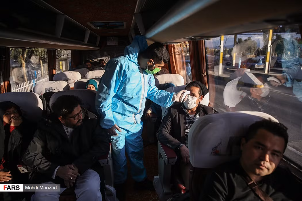 Nhân viên y tế Iran đo thân nhiệt của hành khách trên xe buýt.