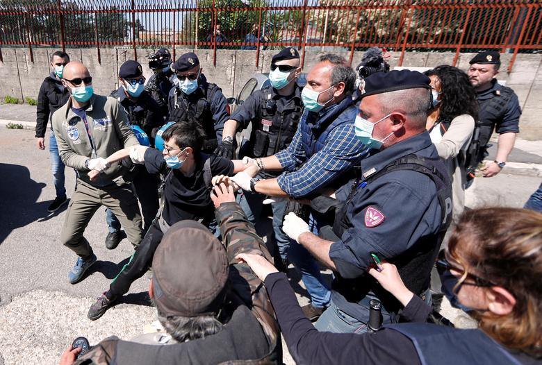 Cảnh sát bắt giữ một thanh niên đeo khẩu trang trong cuộc biểu tình bên ngoài nhà tù Rebibbia ở Rome, Italy, ngày 16/4. Cuộc biểu tình "đòi" cải thiện điều kiện vệ sinh cho các tù nhân trong nhà tù.