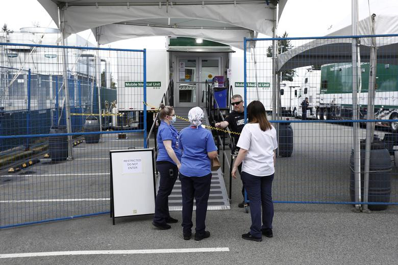 Một nhân viên nhà tù trao đổi với các nhân viên y tế tại một đơn vị y tế di động an toàn được thành lập tại Bệnh viện Abbotsford để điều trị cho các tù nhân bị nhiễm COVID-19, tại British Columbia, Canada, ngày 18/4.