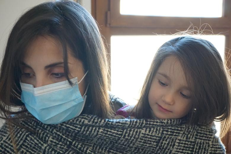 Bác sĩ Cecilia Bartalena đeo khẩu trang khi ôm con gái ở nhà.