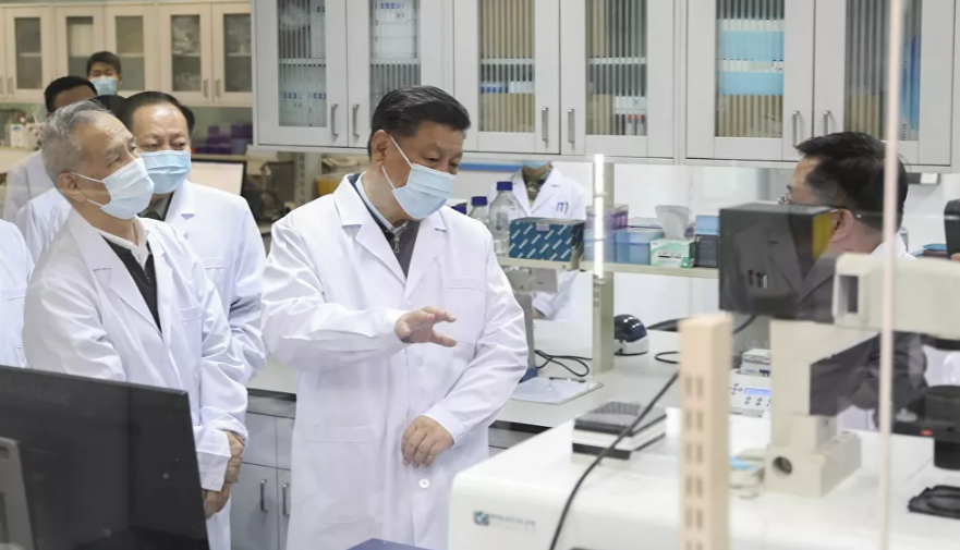 Chủ tịch Trung Quốc Tập Cận Bình đeo khẩu trang khi trao đổi với một nhân viên y tế trong chuyến thăm Viện Khoa học Quân y ở thủ đô Bắc Kinh hôm 2/3.