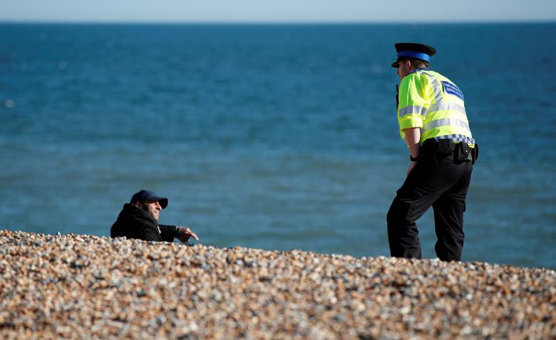 Một nhân viên an ninh nhắc nhở người dân trên bãi biển ở Brighton, Anh, ngày 4/4, giữa lúc dịch bệnh COVID-19 đang bùng phát và lây lan mạnh ở nước này.