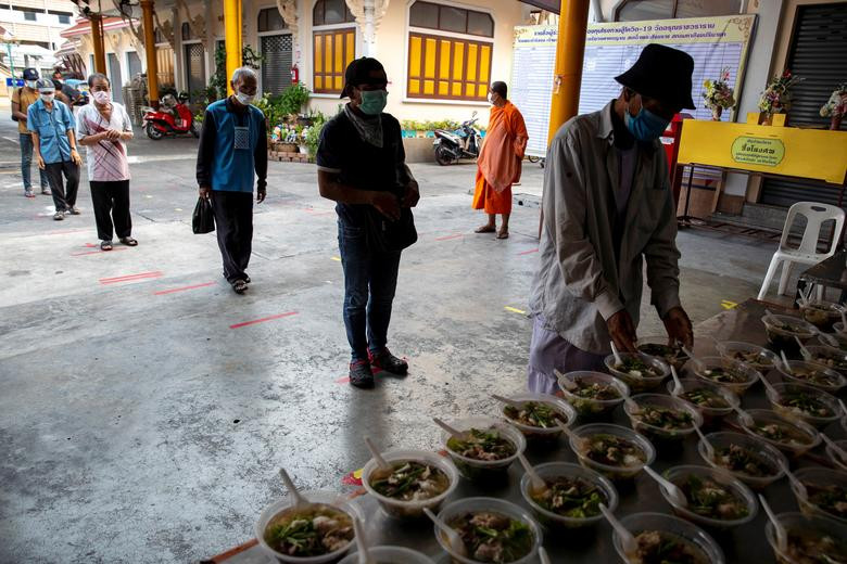 Người vô gia cư xếp hàng nhận đồ ăn tại Wat Arun Ratchavararam ở thủ đô Bangkok, Thái Lan, hôm 2/4.
