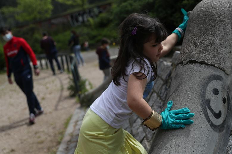 Bé Candela Estrella, 5 tuổi, đeo găng tay khi ra ngoài chơi đùa ở Madrid.