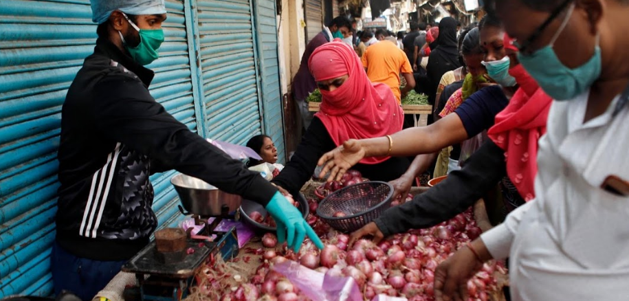 Người dân đeo khẩu trang mua hành trong khu chợ.