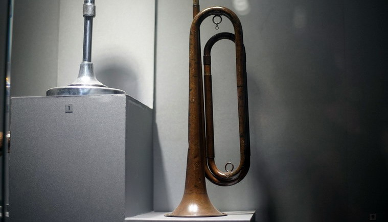 Kèn đồng do nhân dân xã Thuận Thành, huyện Cần Giuộc tịch thu của giặc Pháp trong cuộc biểu tình năm 1930. Ông Nguyễn Văn Báo ở ấp Phú Lạc, xã Đa Phước, huyện Bình Chánh dùng kèn này tập hợp đội Thanh thiếu niên Tiền phong trong cuộc Cách mạng tháng 8 ở Sài Gòn.