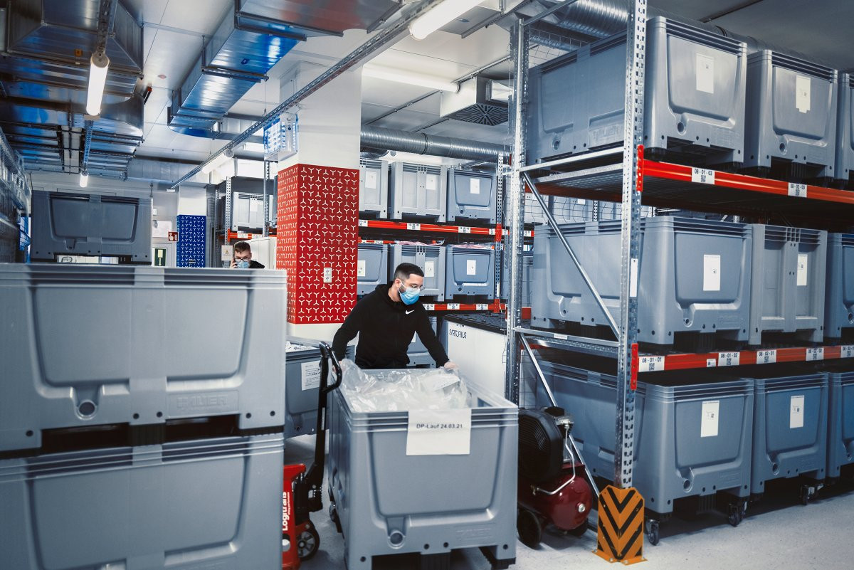 Đây là quản lý kho Tolga Dik. Việc sản xuất vắc-xin cần một lượng lớn nguyên liệu, thiết bị kỹ thuật và vật tư vô trùng. Hầu hết các nguyên liệu vật tư được lưu trữ tại nhà kho ở Marburg.