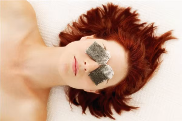  Trà túi lọc có thuộc tính chống kích ứng và có thể làm giảm bọng quanh mắt. Ngâm túi trà, hoặc trà xanh hoặc đen, trong nước nóng, sau đó để túi nguội, đặt túi trà lên mắt. Vết sưng sẽ giảm sau một ít thời gian. 