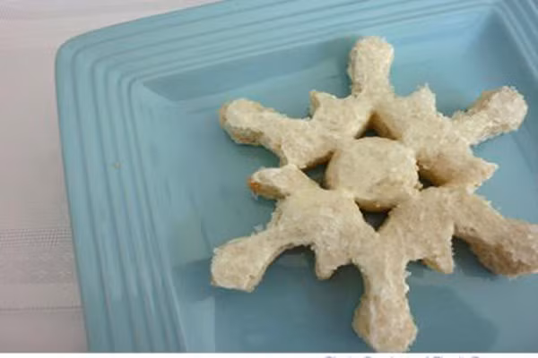 Sanwich hình bông tuyết. Trẻ sẽ rất thích thú với món ăn này trong bữa trưa hoặc tối hay ăn nhẹ. Từ bánh mì, mẹ có thể cắt một bông tuyết lớn. Tăng thêm vị giác cho con bằng cách thêm nước cốt dứa hoặc dâu theo sở thích của con.